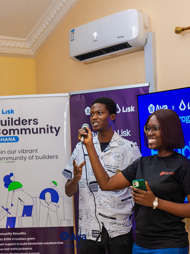 Two people standing by a banner